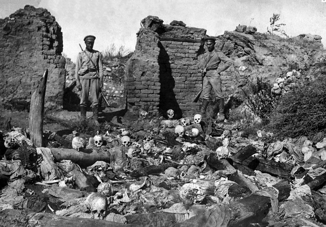 Soldiers standing over skulls of victims from the Armenian village of Sheyxalan in 1915, believed to be victims of the Armenian Holocaust