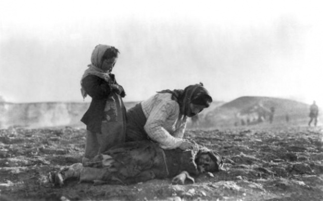 Γυναίκα γονατιστή δίπλα σε ένα παιδί σε μια από τις πορείες θανάτου στην έρημο κοντά στον δρόμο προς το Χαλέπι